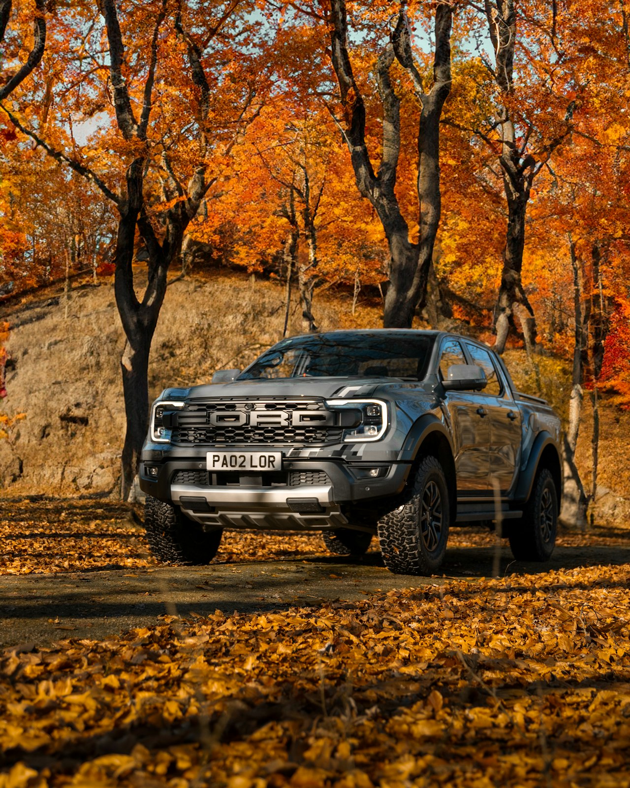 R Ultimate build — black Ford Ranger front three-quarter view on cobblestone